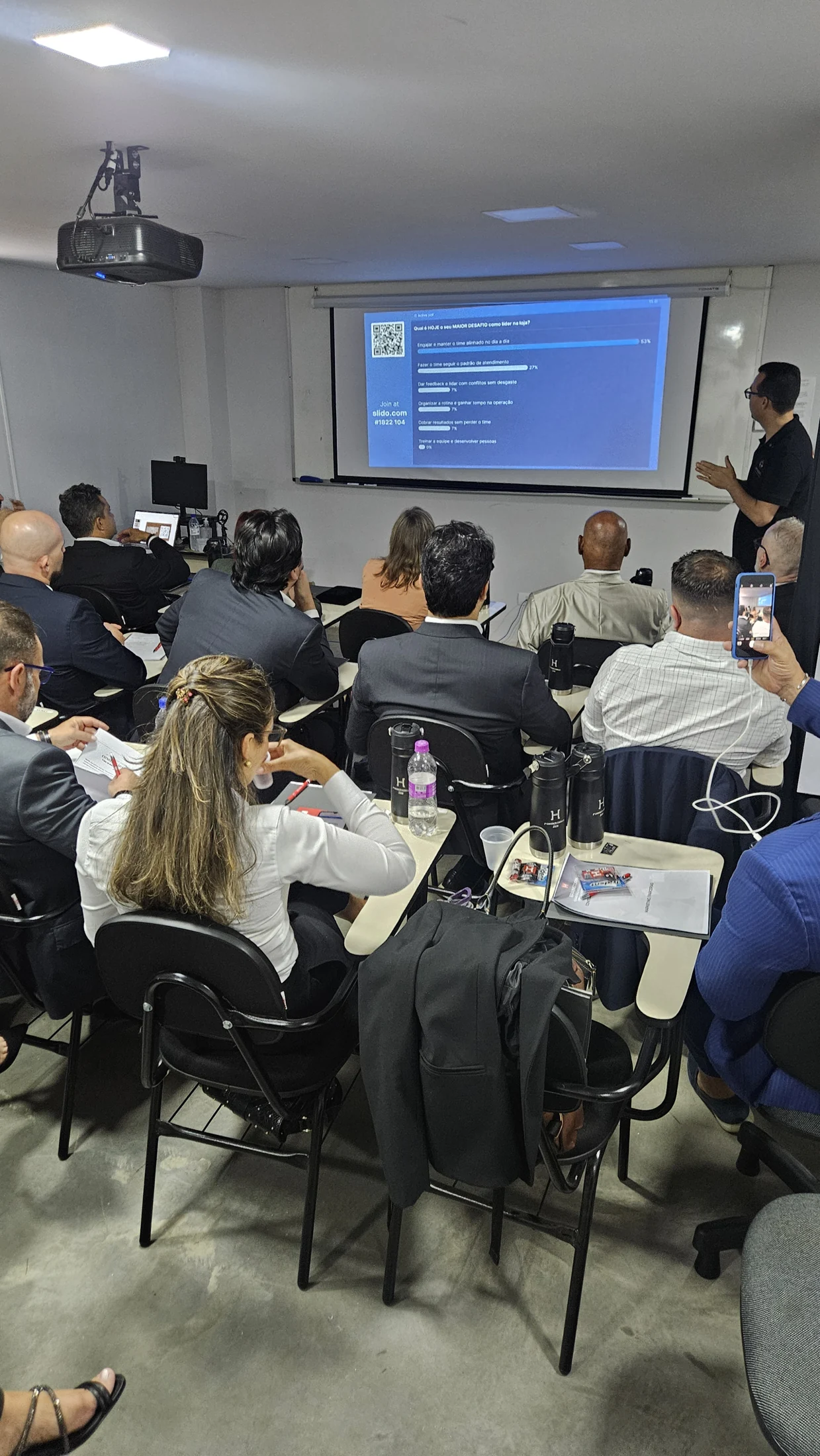 Vista da sala com participantes e projeção durante um encontro na Homem S/A