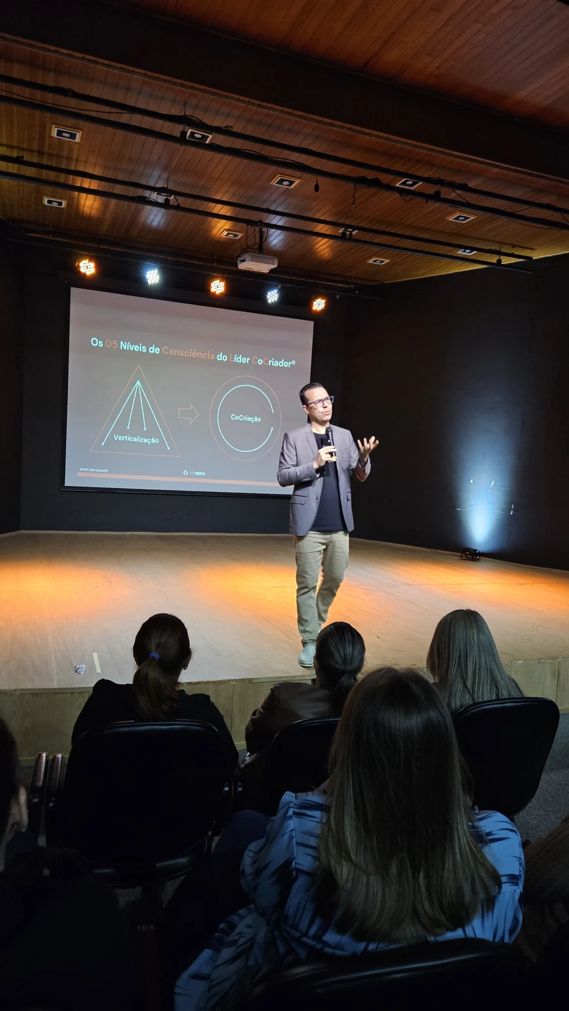 Público reunido diante do palco durante uma palestra